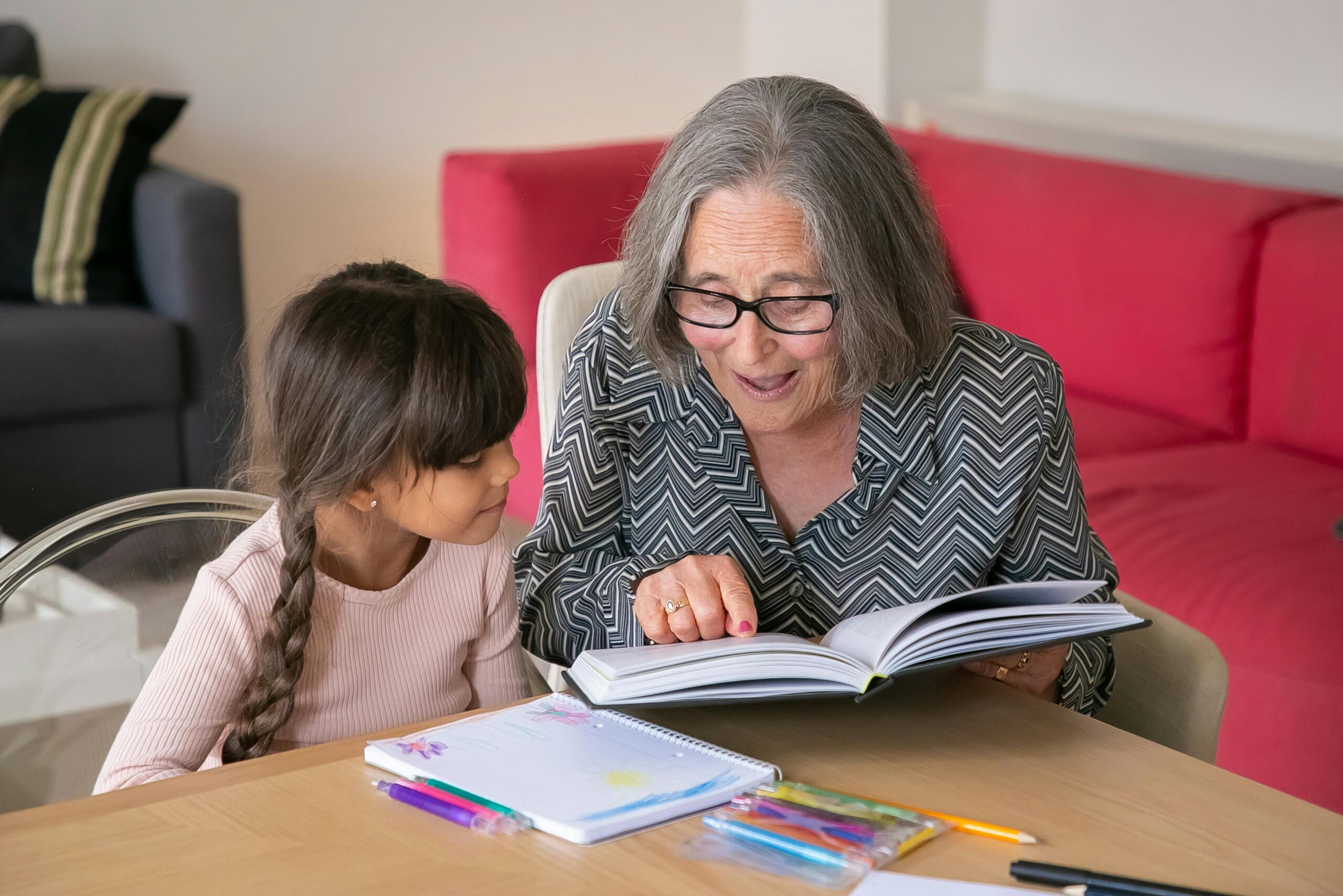 Grandmother helping kid with reading